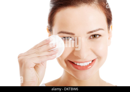 schöne Frau, reinigen ihr Gesicht mit Wattepads. Isoliert auf weiss. Stockfoto