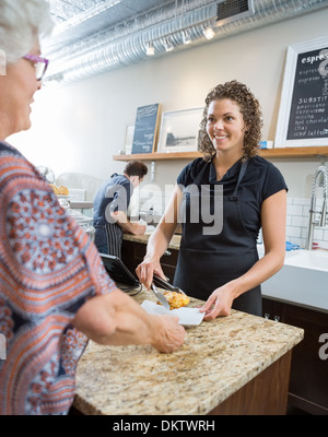 Café-Besitzer, die süßen Speisen, Senior Woman Stockfoto