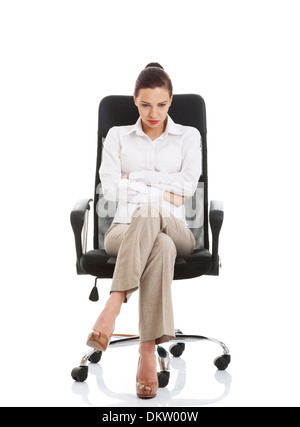Junge traurig Business-Frau auf einem Stuhl sitzend. Isoliert auf weiss. Stockfoto