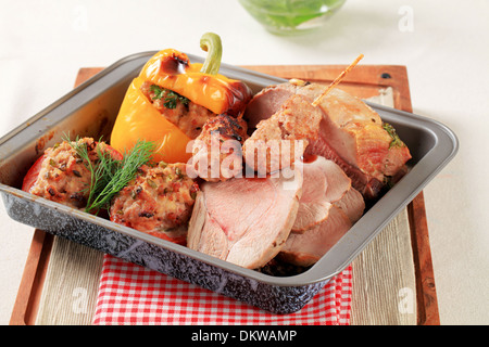 Gebratenes Schweinefleisch, Hackfleisch Kebab und gefüllte Paprika und Tomaten in einer Backform Stockfoto