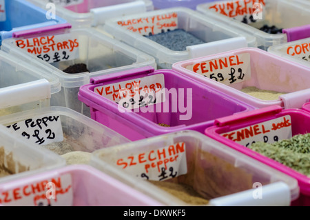 Kräuter und Gewürze in Kunststoffbehältern am Marktstand. Stockfoto