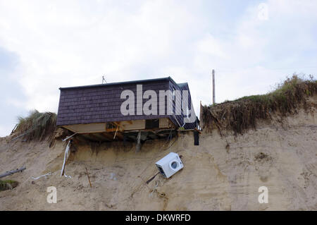 Strand-Haus hängt prekär über Rand der Dünen über Strand als ungewöhnlich hohe Gezeiten Sturmflut das Land darunter weggespült. Szene auf Sonntag, 8. Dezember 2013. Hembsby, Norfolk Stockfoto