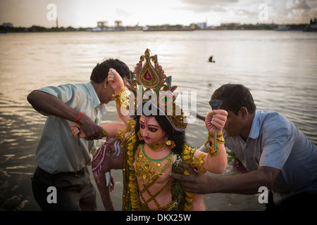 Feiernden bringen eine Statue eines Gottes zu den Gewässern des Hooghly River während Vishwakarm Day in Kalkutta (Kolkata), Indien. Stockfoto