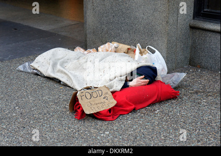 Obdachloser schlafen unter einer Decke auf dem Bürgersteig an der Granville Street in der Innenstadt von Vancouver, BC, Kanada Stockfoto