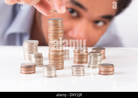 Person auffüllen Münze auf dem höchsten heap Stockfoto
