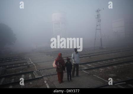 Haryana, Indien. 10. Dezember 2013. Lokale Leute warten, um einen Bahnübergang an einem nebeligen Tag in einem Dorf nahe der Stadt Jind, Haryana, Indien, 10. Dezember 2013 übergeben. Dichten Nebel gehüllt vielerorts im Nordindiens Bundesstaaten Haryana und Punjab, mit Sicht weniger als 200 Meter in einigen Bereichen, die öffentlichen Verkehrsmittel und Leben beeinflussen. Bildnachweis: Zheng Huansong/Xinhua/Alamy Live-Nachrichten Stockfoto