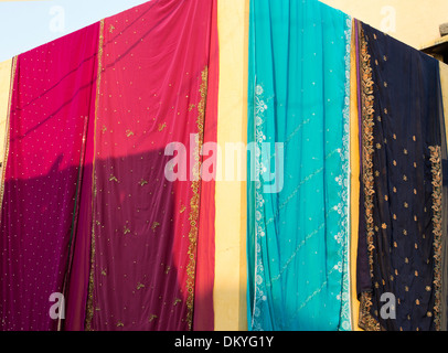 Bunte indische Saris hängen zum Trocknen außerhalb einer indischen Landhaus. Andhra Pradesh, Indien Stockfoto