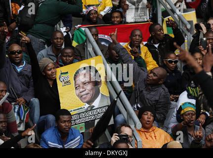 Johannesburg, Südafrika. 10. Dezember 2013. Personen ein Plakat von Nelson Mandela vor der Trauerfeier für den ehemaligen südafrikanischen Präsidenten an das FNB-Stadion in Soweto nahe Johannesburg, Südafrika, 10. Dezember 2013. Bildnachweis: Zhang Chen/Xinhua/Alamy Live-Nachrichten Stockfoto