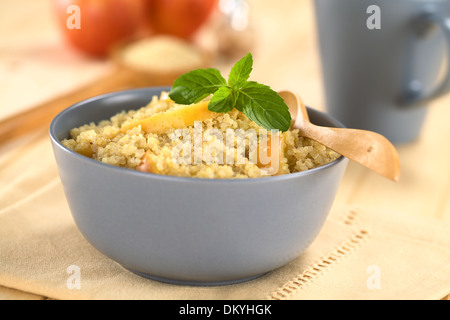 Quinoa-Porridge mit Apfel und Zimt, die einem traditionellen peruanischen Frühstück, garniert mit Minze Stockfoto