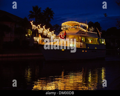 Weihnachts-Dekorationen auf einem Boot in South Carolina. Eine große Motoryacht ist wunderschön dekoriert mit weißen Lichtern und Rentieren. Stockfoto