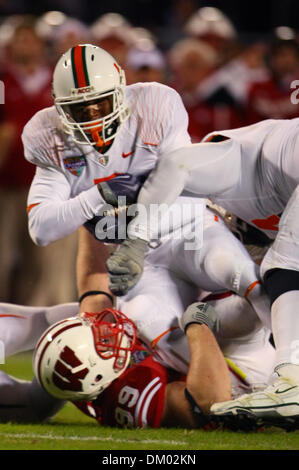 29. Dezember 2009 - Orlando, Florida, USA - 29. Dezember 2009: Miami (FL) Runningback Javarris James #5 durch Miami (FL) defensive Lineman Marcus Forston #99 abgebaut wird. Wisconsin Badgers besiegte die Miami Hurricanes 20-14 in der Champs Sport Bowl im Citrus Bowl in Orlando, Florida (Credit-Bild: © Margaret Bowles/Southcreek Global/ZUMApress.com) Stockfoto