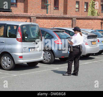 Traffic Warden Ausstellung einen Parkschein für ausländische Besucher Auto in Canterbury, England Stockfoto