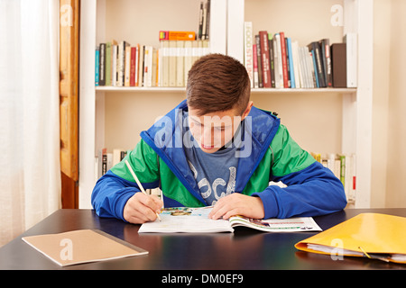 Männlichen Teenager konzentriert Hausaufgaben in einem Schreibtisch Stockfoto