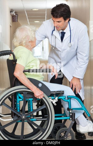Arzt, die Kommunikation mit älteren Frau sitzt im Rollstuhl Stockfoto
