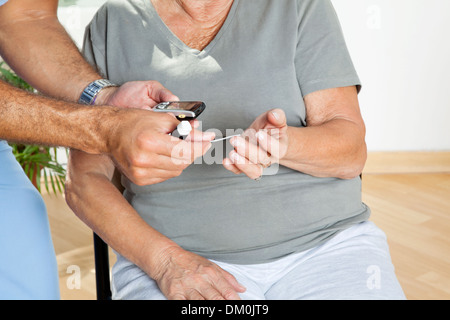 Mann, die Kontrolle des Blutzuckerspiegels von Patienten Stockfoto