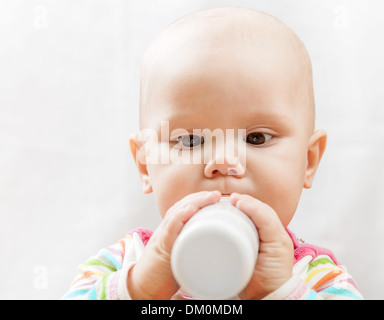 Little, Brown eyed kaukasischen Baby mit Flasche Milch Stockfoto