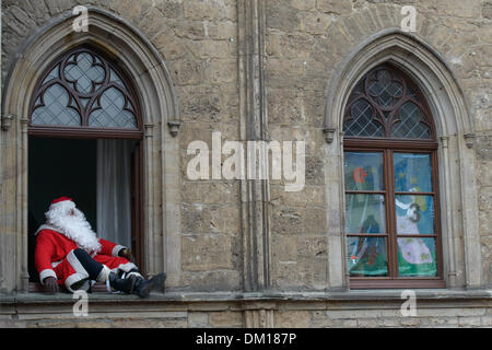 Weimar, Deutschland. 10. Dezember 2013. Ein Mann in ein Weihnachtsmann-Kostüm spricht von einem Fenster in das Rathaus in Weimar, Deutschland, 10. Dezember 2013. Jedes Jahr werden die Fenster des Rathauses in einen riesigen Adventskalender verwandelt. Foto: Candy Welz/ZB/Dpa/Alamy Live News Stockfoto