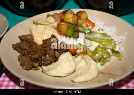 Bhutan, Bhutan Lebensmittel, Teller mit Ema Datse, gedämpfte Momos, Schweinefleisch und gebratenem Gemüse Stockfoto