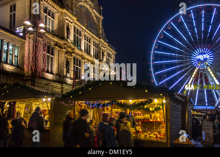 Beleuchtetes Riesenrad und Menschen beim Einkaufen am Abend Weihnachtsmarkt im Winter, Gent, Belgien Stockfoto