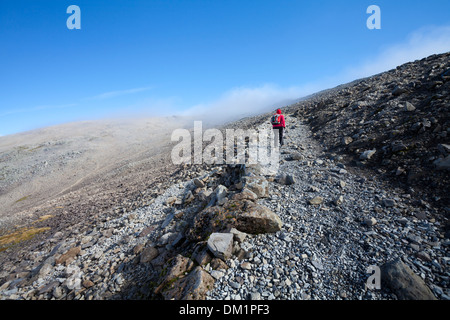 Ben Nevis, Schottland. Ein Walker Köpfe in Richtung Gipfel auf dem Pony Track Fußweg mit niedrigen Wolken voraus. Stockfoto