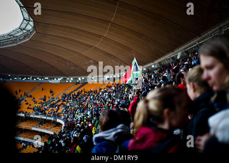 Johannesburg, Südafrika. 10. Dezember 2013. Tausende von Menschen versammelt, um die letzte Ehre, des verstorbenen ehemaligen südafrikanischen Präsidenten, Nelson Mandela, während der offiziellen National Memorial Service Zahlen auf das FNB-Stadion in Soweto, Johannesburg statt. Trauernde singen im Regen während der Feier. Foto: ImageSA/Alamy Live-Nachrichten Stockfoto