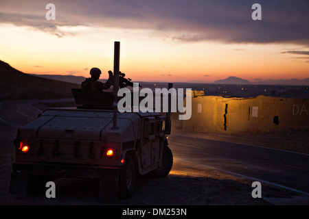 Ein US-Marine bietet Sicherheit von einem Humvee in einem Konvoi außerhalb Forward Operating Base Zeebrugge in der Abenddämmerung 1. Dezember 2013 im Kajaki District, Provinz Helmand, Afghanistan. Stockfoto