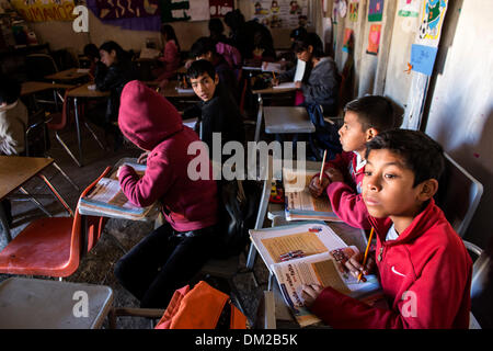 Tijuana, Mexiko. 10. Dezember 2013. Foto aufgenommen am 5. Dezember 2013 zeigt Kinder studieren in ihre Klassenzimmer in der Schule "The New Hope" in Tijuana, Nordwesten Mexikos. Die Schule "New Hope", die gerade vor zwei Monaten eröffnet wurde, hat 51 Studenten vom 1. bis 6. Klasse der Grundschule. Es wird von der National Educational Development Council, der einzige offizielle Institution unterstützt, die ihnen didaktisches Material und eine monatliche Konjunkturprogramme von 1900 Pesos für die beiden Lehrer in der Schule gibt. Die Schule wurde von den Eltern der Schüler, mit Abfallmaterialien gebaut. Stockfoto