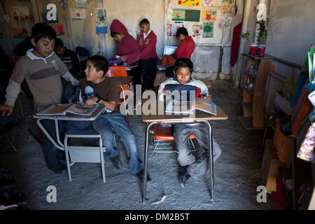 Tijuana, Mexiko. 10. Dezember 2013. Foto aufgenommen am 5. Dezember 2013 zeigt Kinder studieren in ihre Klassenzimmer in der Schule "The New Hope" in Tijuana, Nordwesten Mexikos. Die Schule "New Hope", die gerade vor zwei Monaten eröffnet wurde, hat 51 Studenten vom 1. bis 6. Klasse der Grundschule. Es wird von der National Educational Development Council, der einzige offizielle Institution unterstützt, die ihnen didaktisches Material und eine monatliche Konjunkturprogramme von 1900 Pesos für die beiden Lehrer in der Schule gibt. Die Schule wurde von den Eltern der Schüler, mit Abfallmaterialien gebaut. Stockfoto