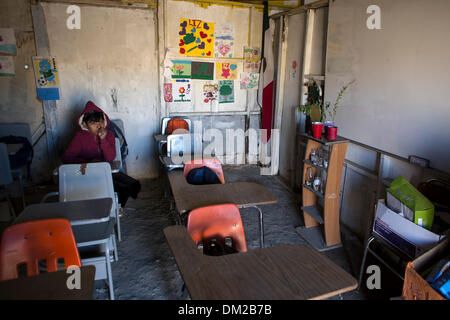 Tijuana, Mexiko. 10. Dezember 2013. Foto aufgenommen am 5. Dezember 2013 zeigt einen jungen in seinem Klassenzimmer in der Schule "The New Hope" in Tijuana, nordwestlichen Mexiko bleiben. Die Schule "New Hope", die gerade vor zwei Monaten eröffnet wurde, hat 51 Studenten vom 1. bis 6. Klasse der Grundschule. Es wird von der National Educational Development Council, der einzige offizielle Institution unterstützt, die ihnen didaktisches Material und eine monatliche Konjunkturprogramme von 1900 Pesos für die beiden Lehrer in der Schule gibt. Die Schule wurde von den Eltern der Schüler, mit Abfallmaterialien gebaut. Stockfoto