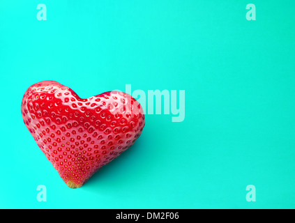 Eine reiche Erdbeere Frucht in Form von Herzen auf blauem Grund. Stockfoto