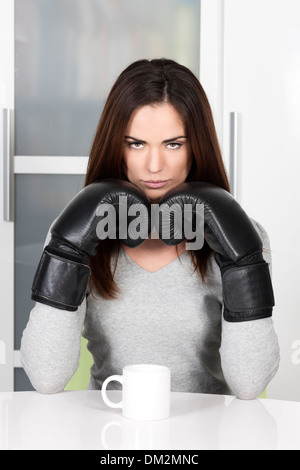 sehr müde aussehende Frau in den frühen Morgenstunden eine Tasse Kaffee trinken Stockfoto