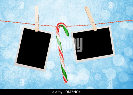 Leere Fotos und Zuckerstange Wäscheleine hängen, über blaue Weihnachten Hintergrund Stockfoto