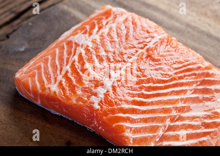 Lachsfilet mit Gewürzen auf einem Brett aus Holz schnitzen. Makroaufnahme. Stockfoto