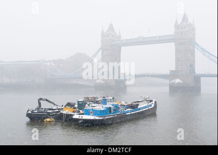 Schnee fällt auf Lastkähne festgemacht an der Themse vor der Tower Bridge, London, England Stockfoto