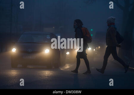 London, UK. 11. Dezember 2013: Londoner machen ihren Weg zur Arbeit in der Morgendämmerung in dichtem Nebel. London und der Südosten von schlechter Sicht und schlechten Straßenverhältnissen machen Reisen ein weiteres Elend Wintertag betroffen. Bildnachweis: Richard Baker / Alamy Live News Stockfoto