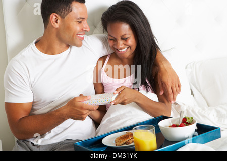 Mann Frau Frühstück im Bett am Feiertag zu bringen Stockfoto