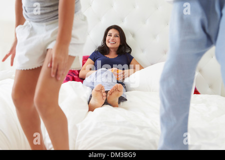 Mutter und Kinder entspannend im Bett tragen Pyjama Stockfoto