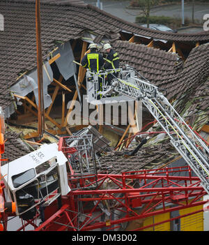 Bad Homburg, Deutschland. 11. Dezember 2013. Das Dach ist teilweise zusammengebrochen, nachdem ein Kran nach unten auf das Dach eines Supermarktes in Bad Homburg, Deutschland, 11. Dezember 2013 stürzte. Derzeit, sagte die Polizei dort ein paar Menschen verletzt wurden. Foto: FRANK RUMPENHORST/Dpa/Alamy Live News Stockfoto