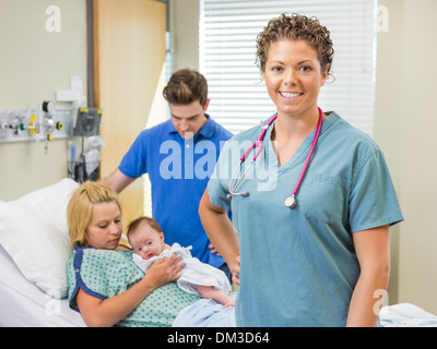 Krankenschwester mit paar und Neugeborene im Hintergrund stehen Stockfoto
