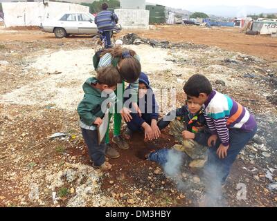 (131211)--BEIRUT, 11. Dezember 2013 (Xinhua)--syrischer Flüchtling Kinder machen ein Feuer zum warm werden in einem Flüchtlingslager im Südlibanon, 11. Dezember 2013. Da der Winter vor der Tür ist, wird wie die kalte Temperaturen ertragen zum Problem für syrische Flüchtlinge im Libanon. (Xinhua) (Dzl) Stockfoto