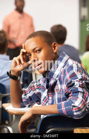 Gelangweilt männliche Teenager Schüler im Klassenzimmer Stockfoto