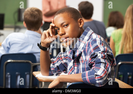 Gelangweilt männliche Teenager Schüler im Klassenzimmer Stockfoto