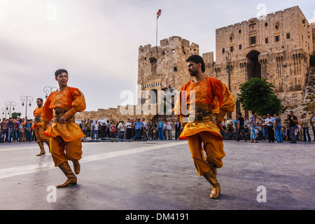 Tänzerinnen in traditionellen Kostümen durch die Zitadelle von Aleppo, Syrien Stockfoto