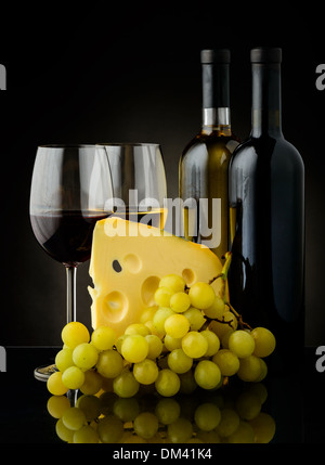 Stillleben mit Weintrauben und Käse auf einem schwarzen Hintergrund Stockfoto