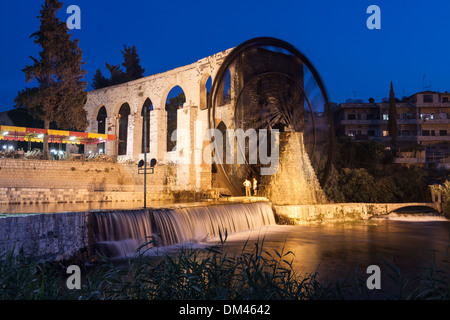 Al Mohammediyya Noria, die größte die Wasserräder von Hama beleuchtet in der Abenddämmerung. Hama, Syrien Stockfoto