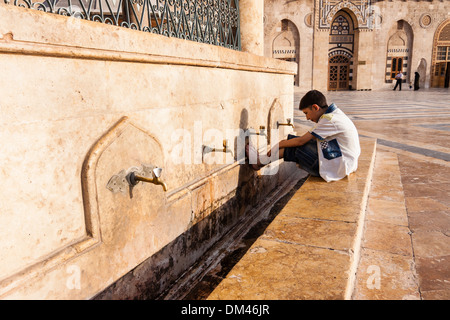 Junge seine Fußwaschung vor dem Gebet in der großen Moschee von Aleppo, Syrien Stockfoto