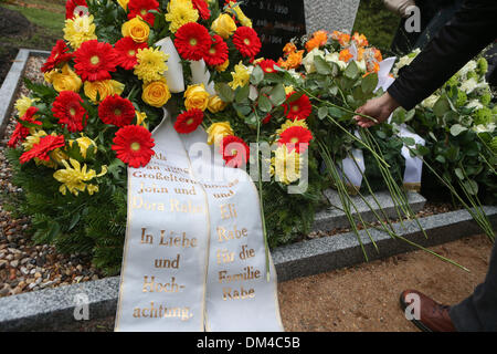 Berlin, Deutschland. 11. Dezember 2013. Ein Besucher legt eine Blume während der Einweihung des Denkmals von John Rabe in Berlin, Deutschland, am 11. Dezember 2013. Eröffnungsfeier der Gedenkfriedhof widmet sich Siemens Geschäftsmann John Rabe, die Leben von Hunderten von Tausenden von Chinesen in Nanjing während des zweiten Weltkriegs gerettet, war am Mittwoch in Berlin statt. Bildnachweis: Zhang Fan/Xinhua/Alamy Live-Nachrichten Stockfoto