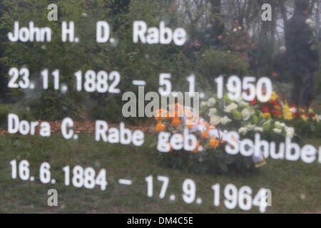 Berlin, Deutschland. 11. Dezember 2013. Besucher sind auf das Denkmal von John Rabe während seiner Einweihung in Berlin, Deutschland, am 11. Dezember 2013 reflektiert. Eröffnungsfeier der Gedenkfriedhof widmet sich Siemens Geschäftsmann John Rabe, die Leben von Hunderten von Tausenden von Chinesen in Nanjing während des zweiten Weltkriegs gerettet, war am Mittwoch in Berlin statt. (Xinhua/Zhang Fan) Bildnachweis: Zhang Fan/Xinhua/Alamy Live-Nachrichten Stockfoto