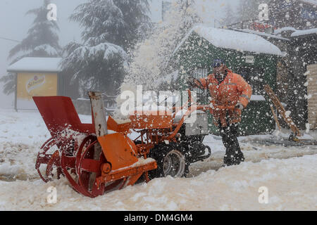 Golan-Höhen. 11. Dezember 2013. Ein Arbeiter des Mount Hermon Ski Resort stürzt Schnee in den Golan-Höhen, am 11. Dezember 2013. Am Mittwoch war es stürmisch in den meisten Israel und Schnee auf den Golanhöhen, und es wird in regelmäßigen Abständen in den nördlichen Golanhöhen, Schnee, mit Temperaturen weiter um 0 Grad Celsius fallen. Bildnachweis: JINI/Xinhua/Alamy Live-Nachrichten Stockfoto