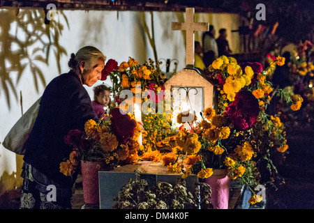 Familienmitglieder Kerzen zu Ehren der Toten im Friedhof von San Felipe de Aqua im Laufe des Tages von den Dead Festival in Spanisch als Día de Muertos am 2. November 2013 in Oaxaca, Mexiko bekannt. Stockfoto